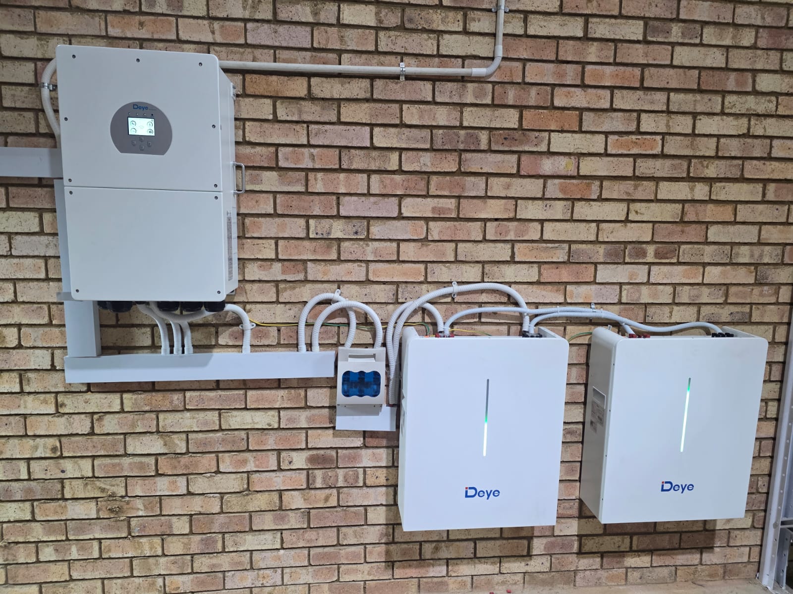 Inverter and battery bank mounted on a face-brick wall